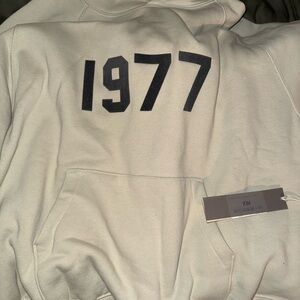 Essentials Off-White Hoodie with Black 1977 Print
